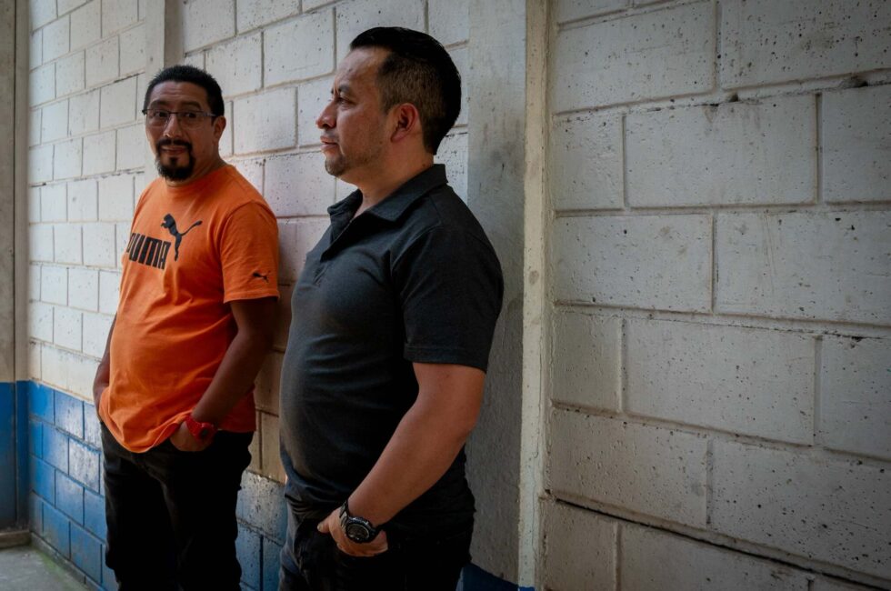 Los exdirigentes de los 48 Cantones Luis Pacheco (a la derecha) y Héctor Chaclán, en un pasillo de la cárcel Mariscal Zavala, donde llevan más de un año en detención provisional acusados de terrorismo por encabezar las protestas pacíficas de 2023. Foto: Nathalie Quan.